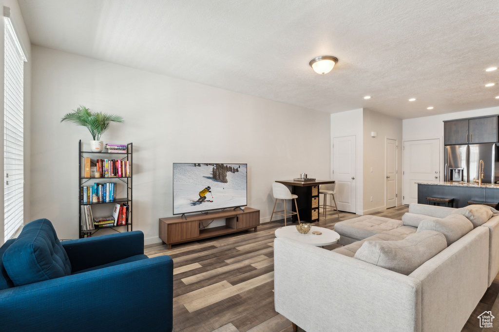 Living room with baseboards, recessed lighting, and wood finished floors