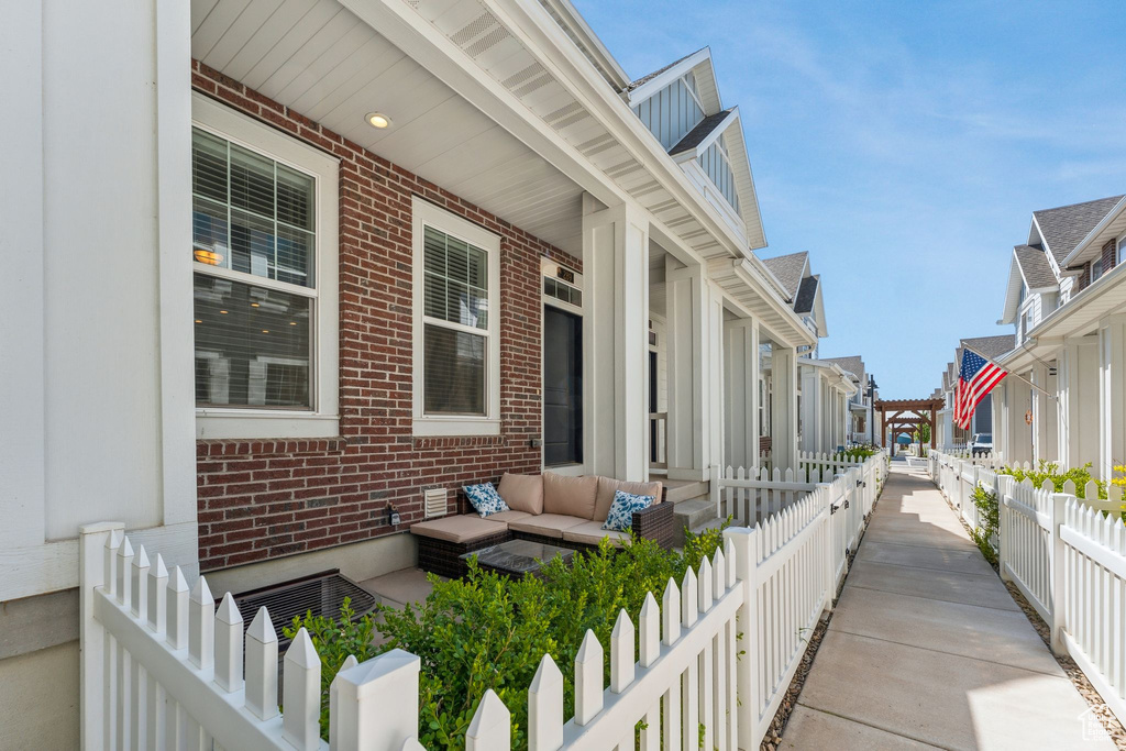 View of side of home featuring a residential view, an outdoor hangout area, brick siding, and a fenced backyard