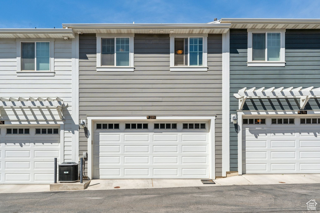 View of front of home featuring a garage and central air condition unit