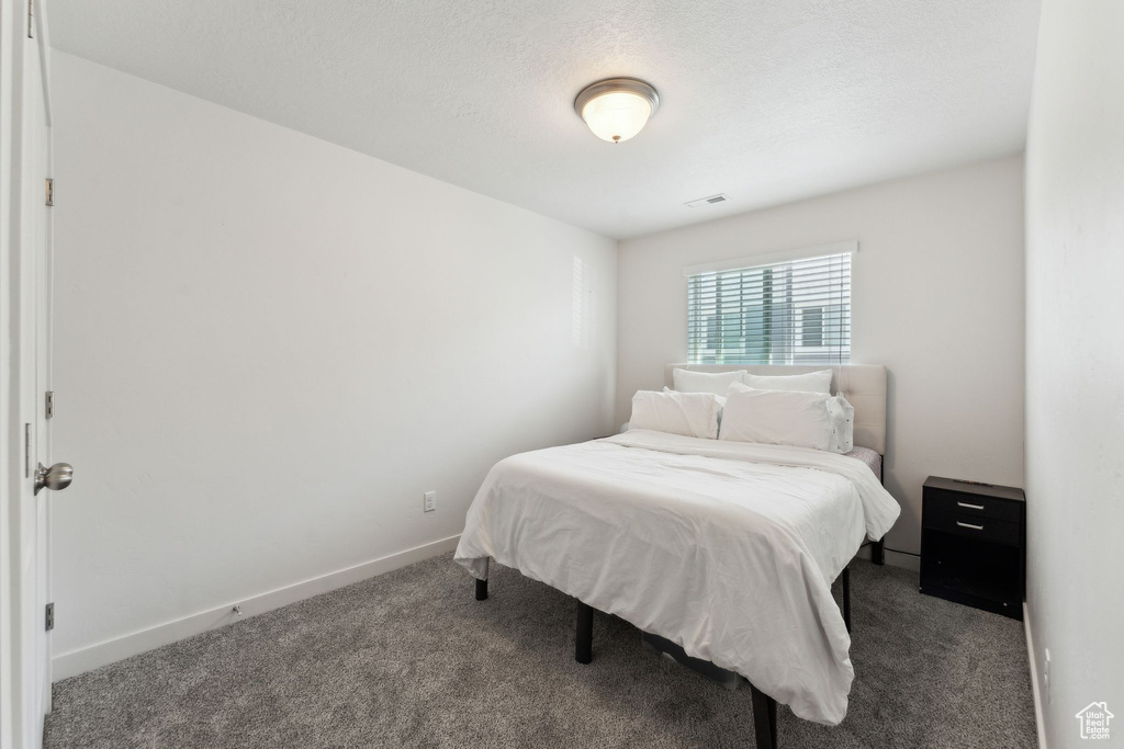 Bedroom with baseboards, visible vents, and carpet flooring