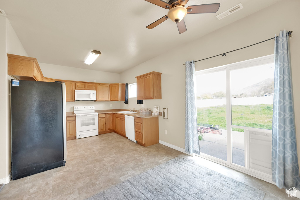 Kitchen featuring visible vents, light countertops, light brown cabinetry, white appliances, and a ceiling fan