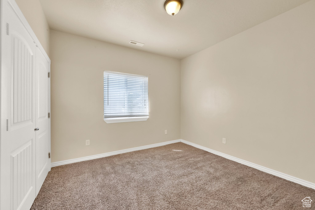 Unfurnished bedroom featuring visible vents, a closet, carpet flooring, and baseboards