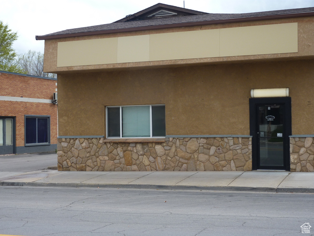 Exterior space featuring stone siding and stucco siding