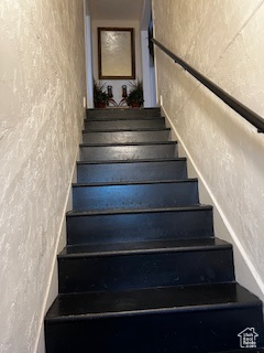 Staircase featuring a textured wall