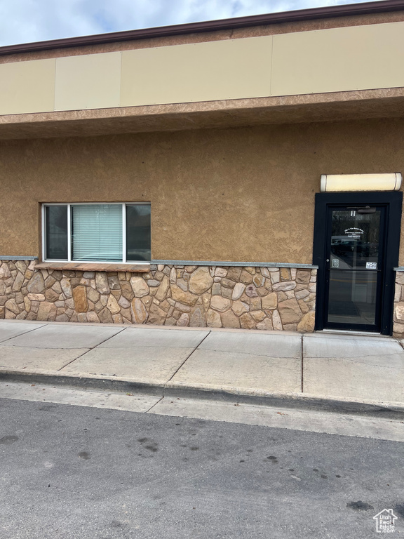 View of exterior entry with stucco siding and stone siding