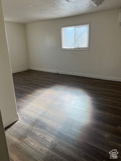 Unfurnished room featuring dark wood finished floors and baseboards