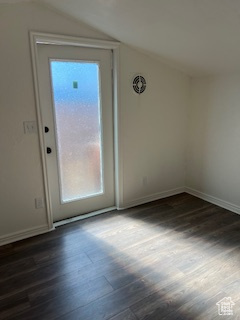 Interior space featuring vaulted ceiling, a wealth of natural light, dark wood-style floors, and baseboards