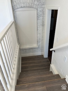 Stairs with wood finished floors and baseboards