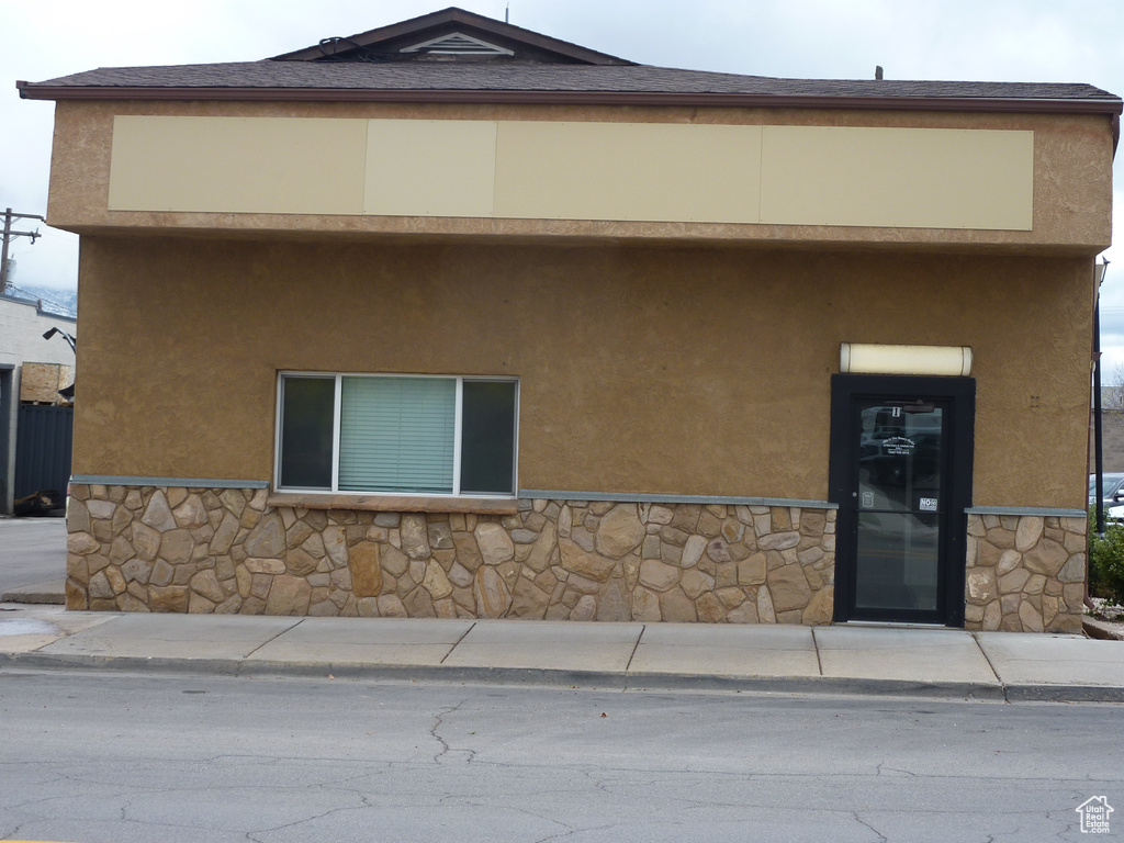 View of front of house featuring stucco siding and stone siding