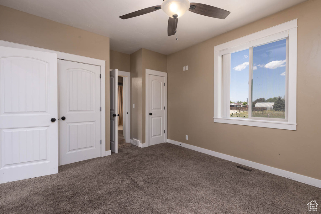 Unfurnished bedroom with carpet, baseboards, and a ceiling fan