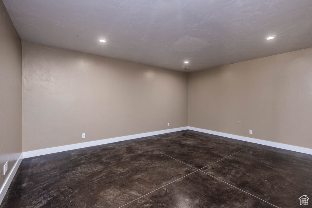 Unfurnished room featuring concrete flooring, baseboards, and recessed lighting