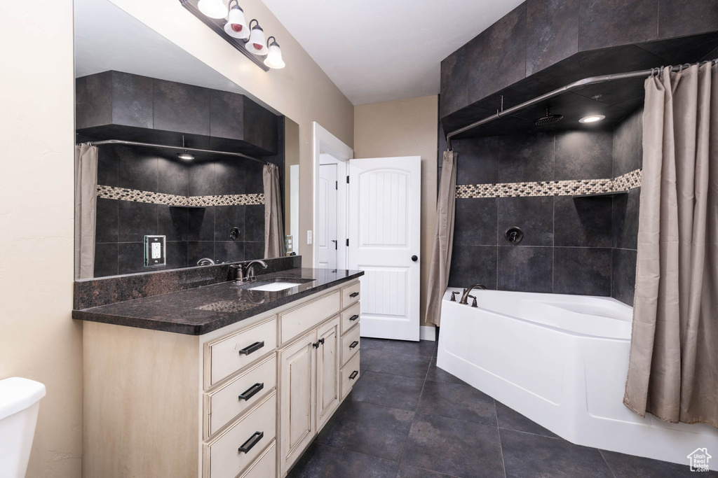 Bathroom featuring vanity, a combined bath / shower with rainfall shower, and toilet
