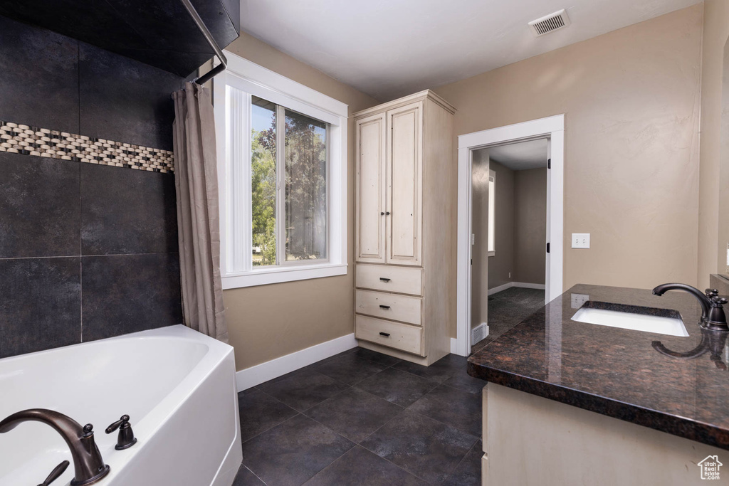 Bathroom featuring vanity, baseboards, tile patterned flooring, and shower / tub combo with curtain