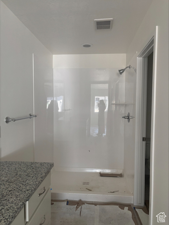 Full bath featuring visible vents, a stall shower, and vanity