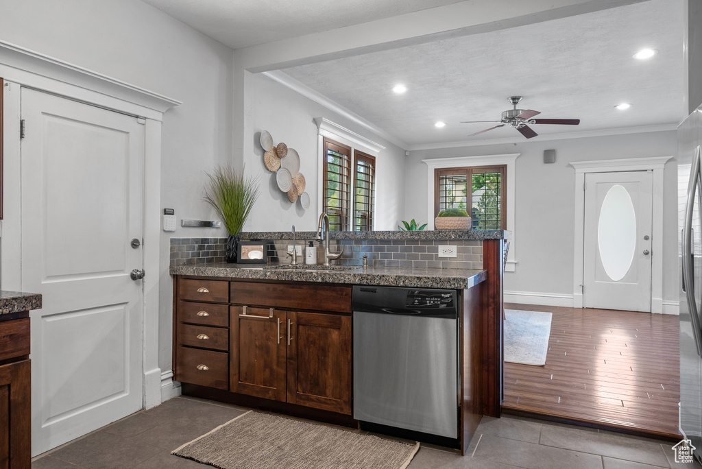 Kitchen featuring stainless steel dishwasher, a sink, a peninsula, ceiling fan, and light tile patterned floors