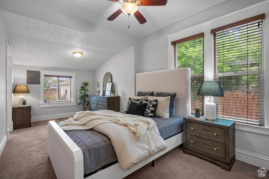 Carpeted bedroom featuring electric panel, baseboards, vaulted ceiling, and ceiling fan