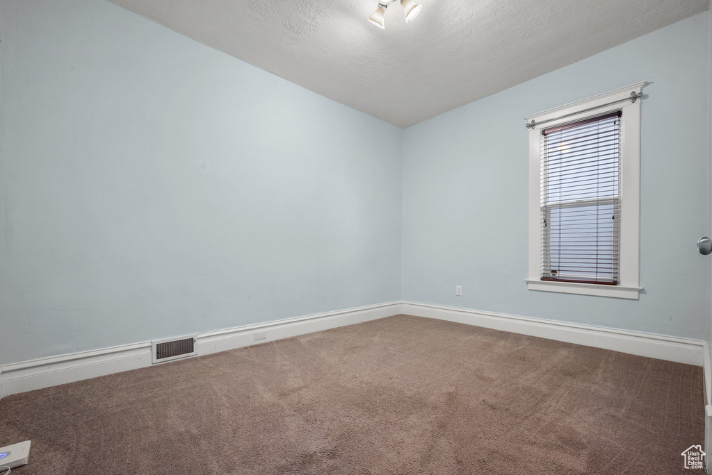 Spare room featuring carpet floors and baseboards