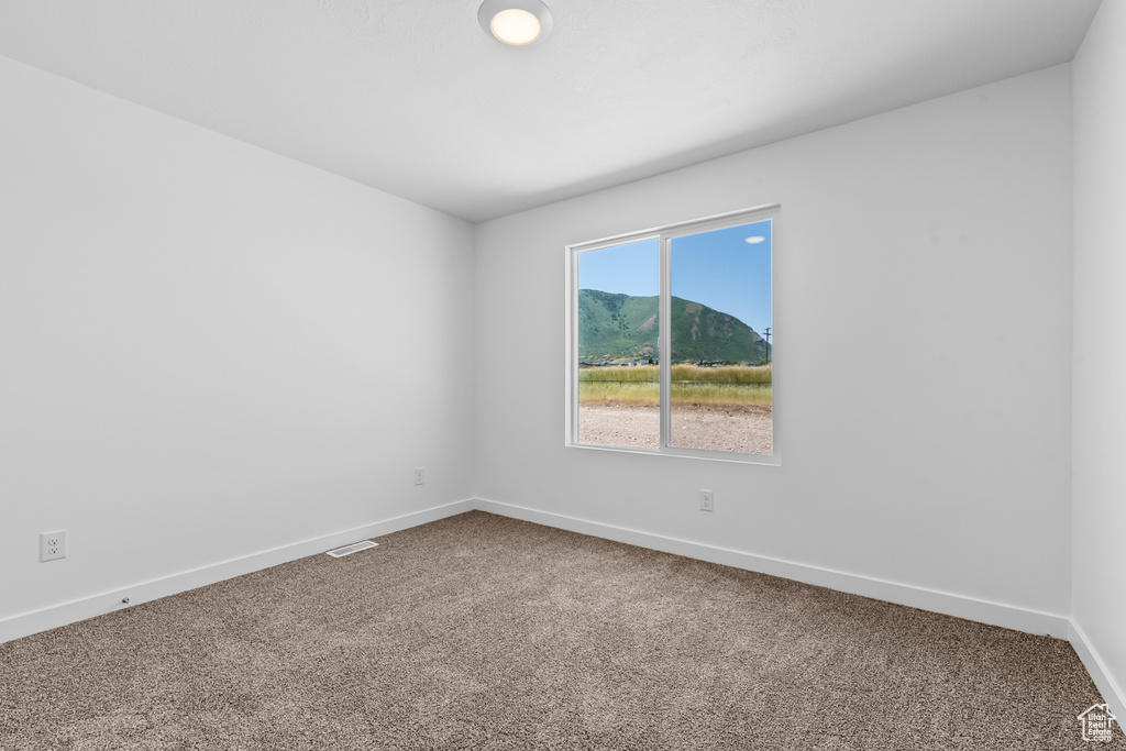 Empty room with visible vents, baseboards, and carpet floors