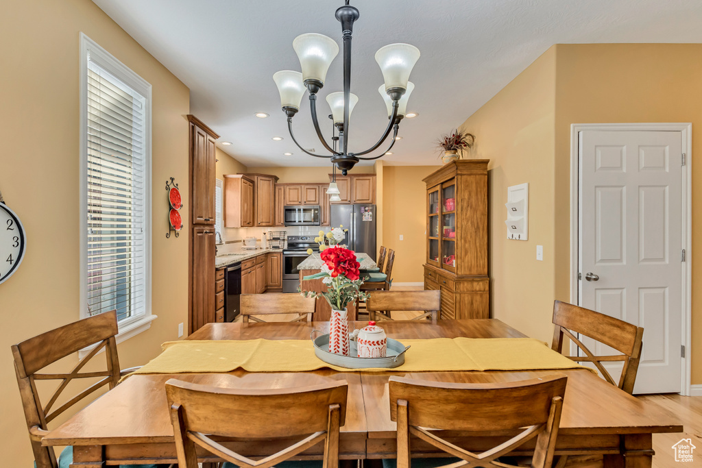 Dining room featuring baseboards, recessed lighting, a notable chandelier, and light wood finished floors