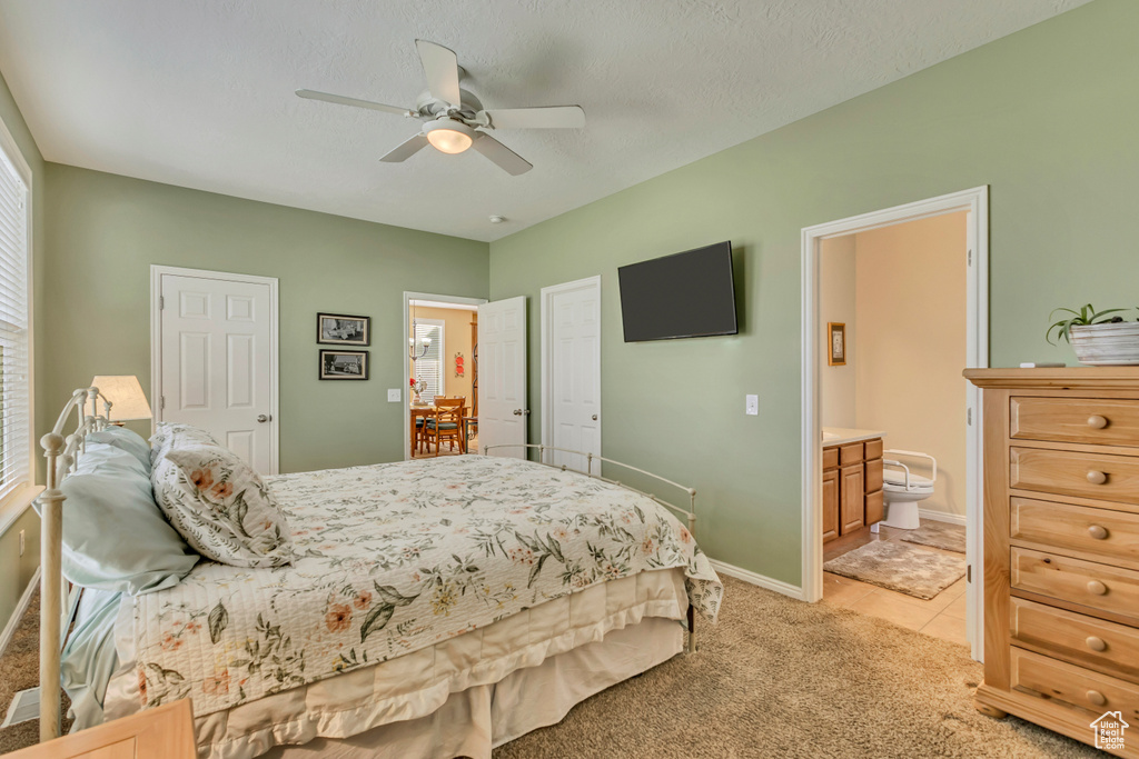 Bedroom featuring baseboards, a ceiling fan, connected bathroom, and light colored carpet