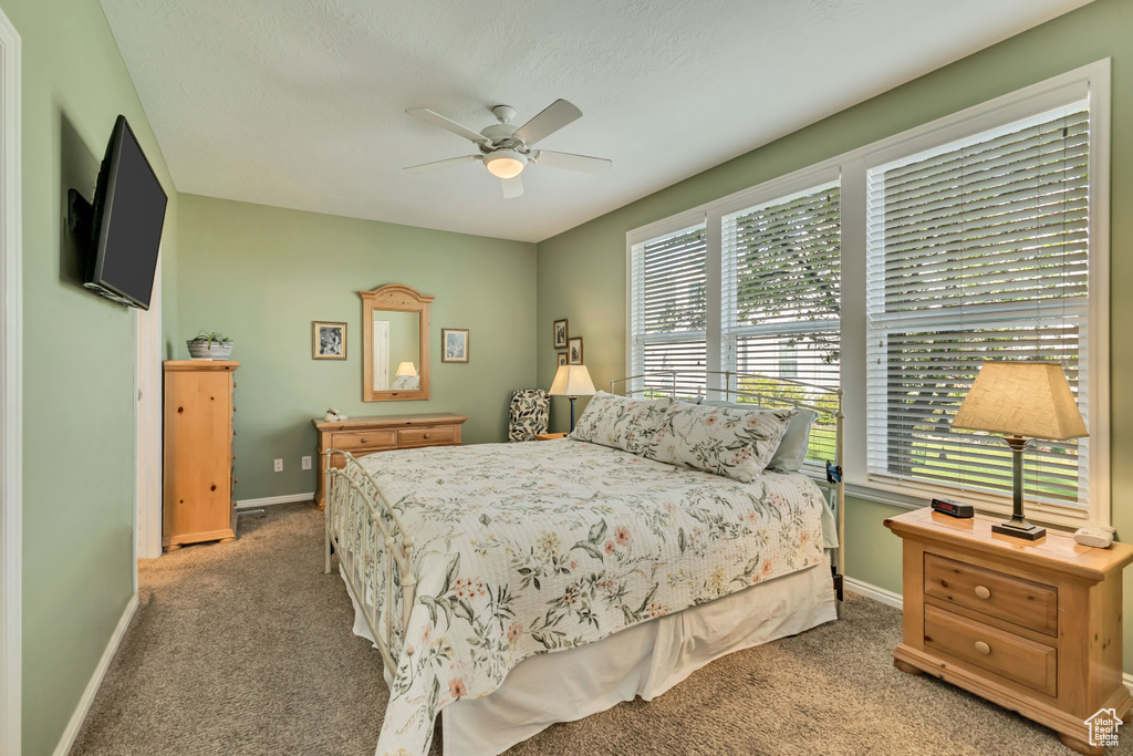 Bedroom with baseboards, a ceiling fan, and light carpet