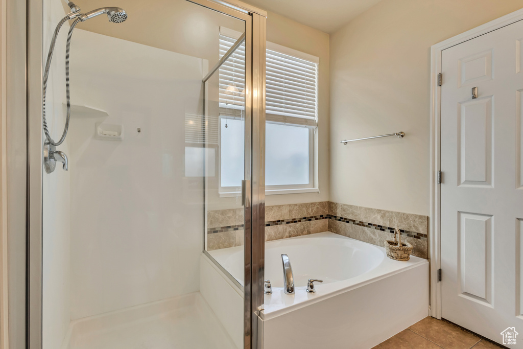Full bath featuring tile patterned floors, a bath, and a stall shower