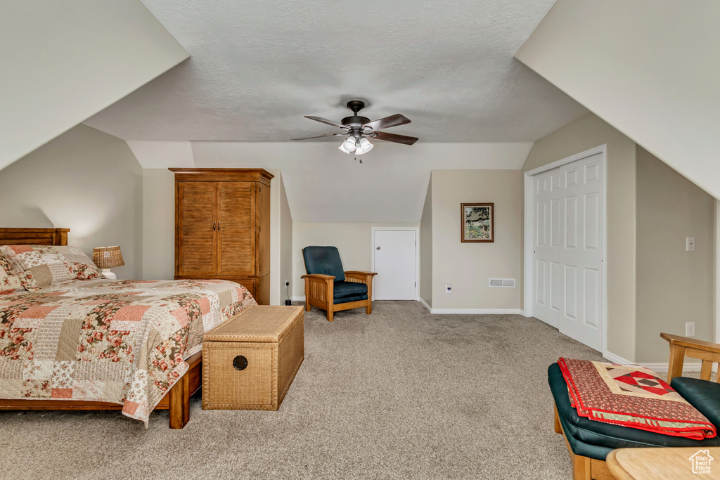 Bedroom featuring carpet flooring, baseboards, visible vents, a ceiling fan, and lofted ceiling