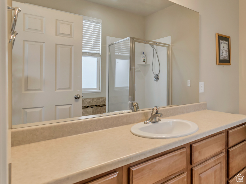 Bathroom featuring tile patterned floors, toilet, vanity, baseboards, and a stall shower