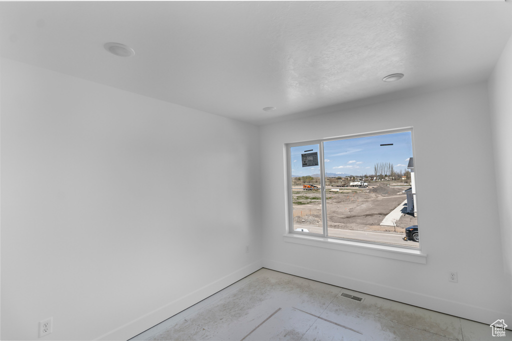 Spare room with concrete floors, visible vents, and baseboards