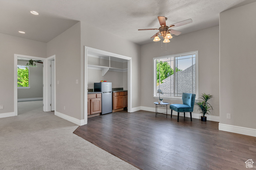 Sitting room featuring a ceiling fan, plenty of natural light, baseboards, recessed lighting, and dark wood-style floors