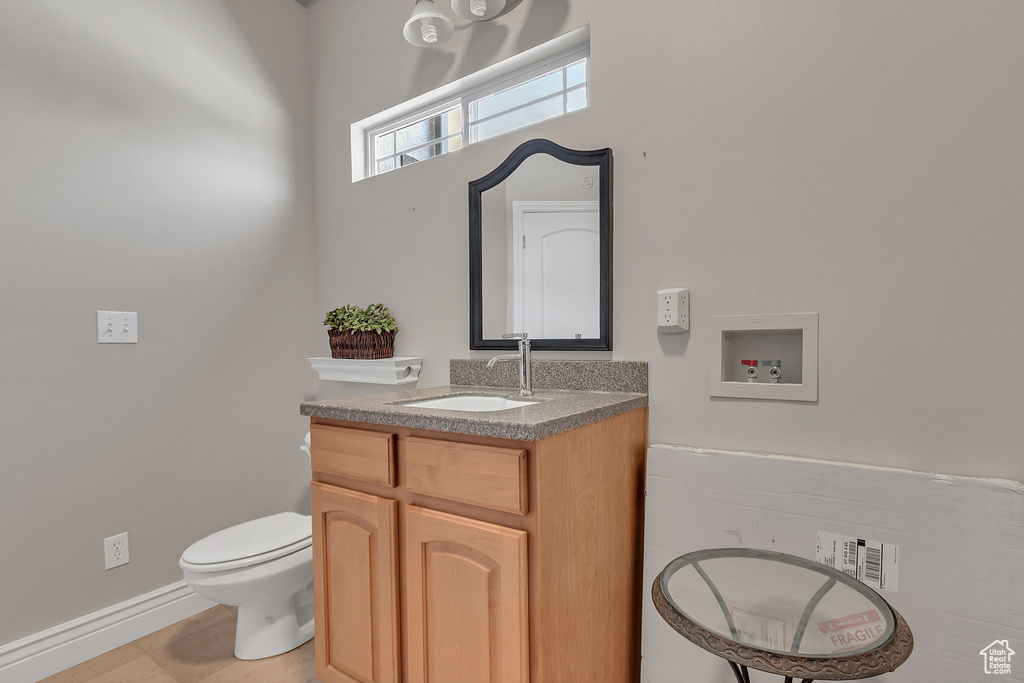 Half bathroom featuring vanity and toilet