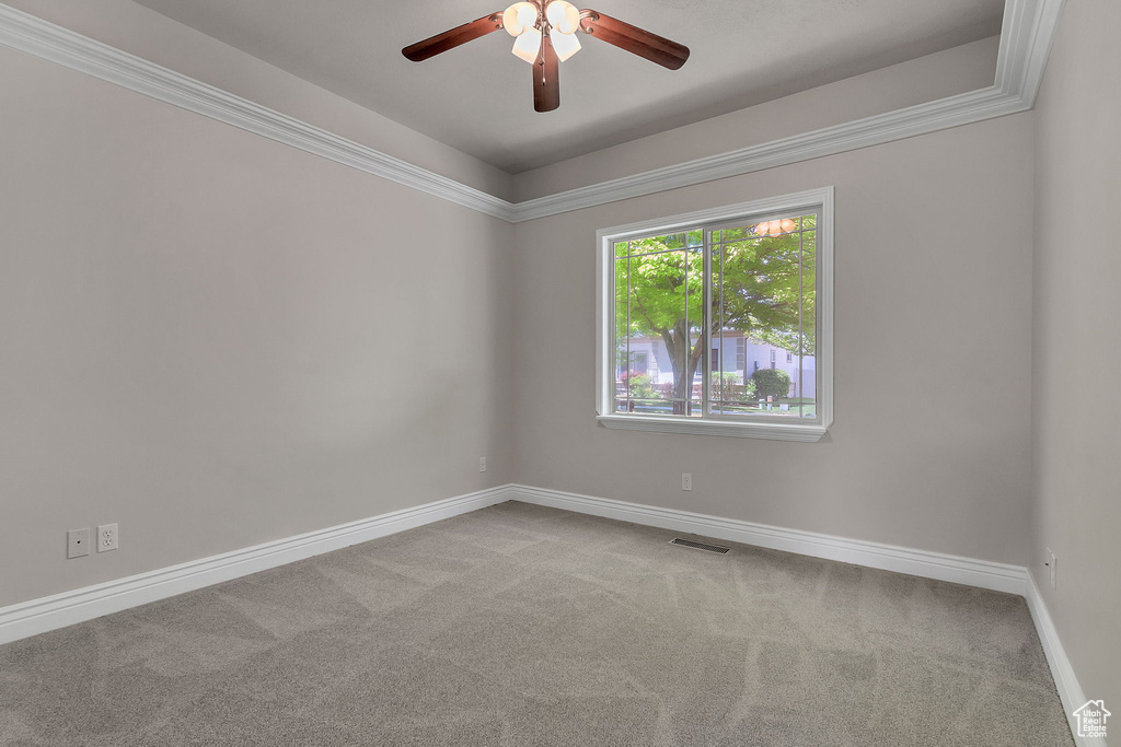 Carpeted empty room with ceiling fan and baseboards
