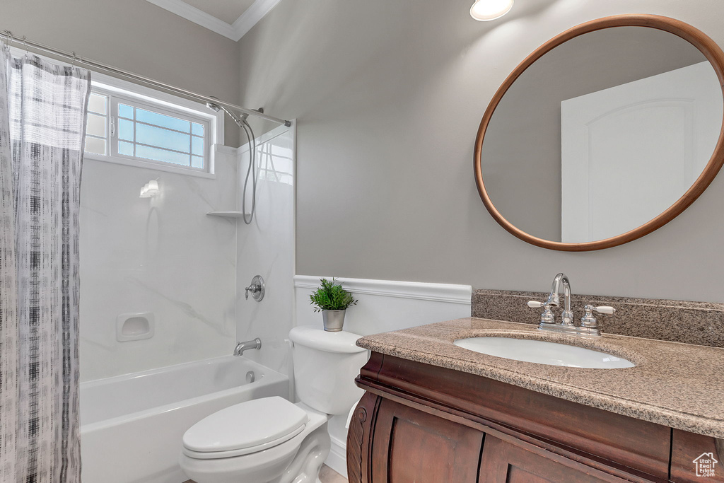 Full bathroom featuring shower / bath combo with shower curtain, ornamental molding, toilet, and vanity