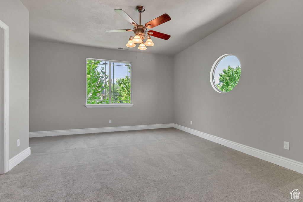 Spare room featuring carpet, a ceiling fan, and baseboards