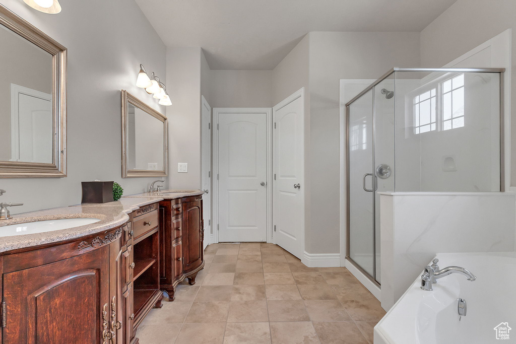 Full bath featuring a bath, a stall shower, double vanity, and tile patterned flooring