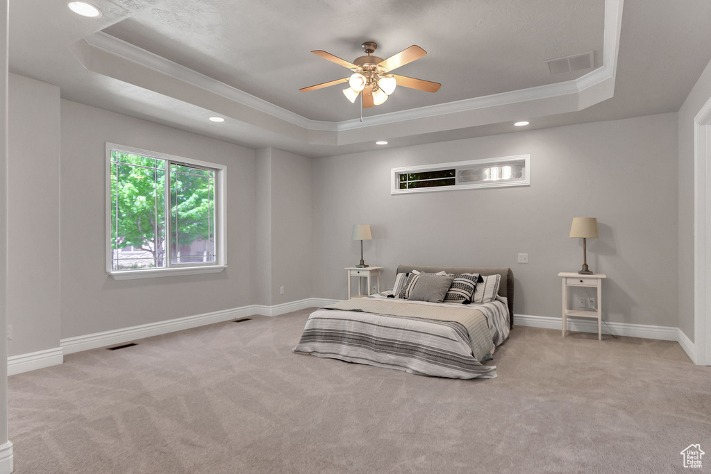 Bedroom with a tray ceiling, ornamental molding, carpet flooring, baseboards, and recessed lighting