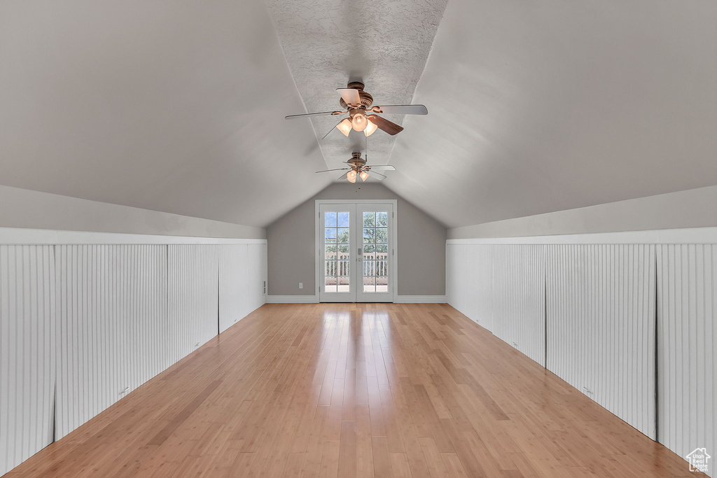 Additional living space with light wood-type flooring, ceiling fan, and lofted ceiling