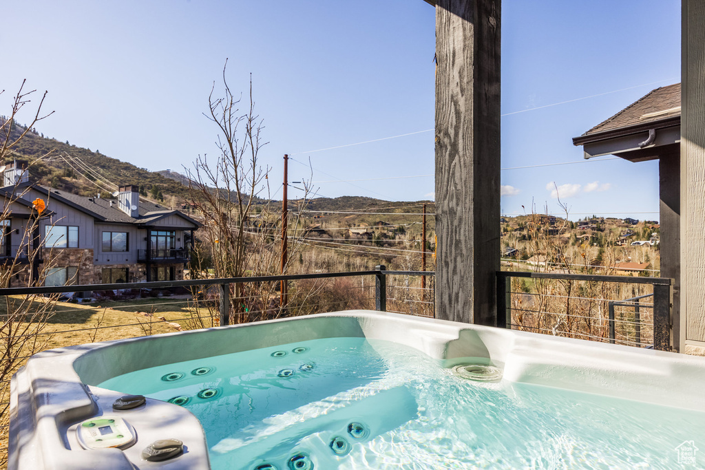 View of pool with a mountain view and a hot tub