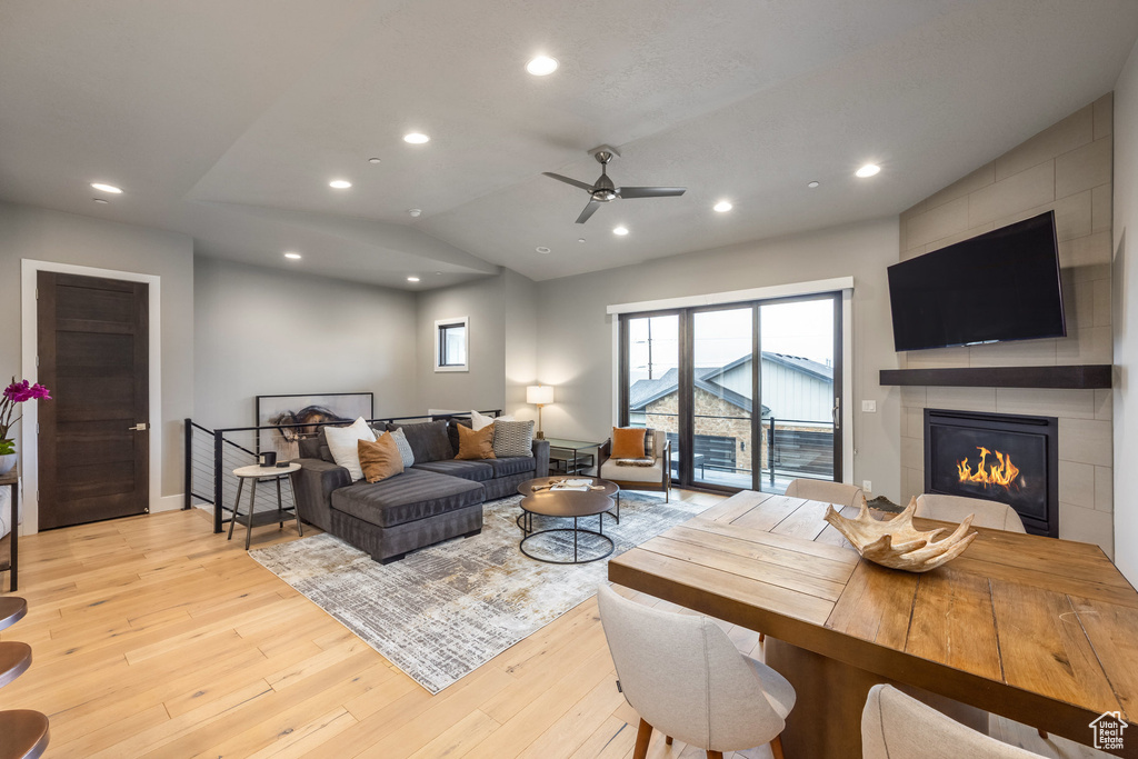 Living room featuring light wood-style floors, a tiled fireplace, and recessed lighting