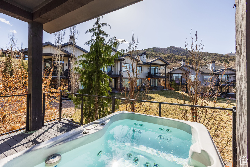 View of swimming pool with a residential view, a mountain view, and a hot tub