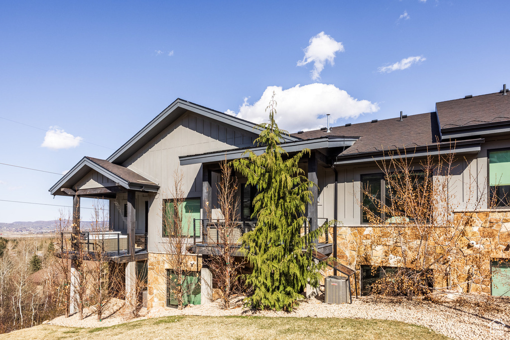 View of front of property with a shingled roof and a balcony