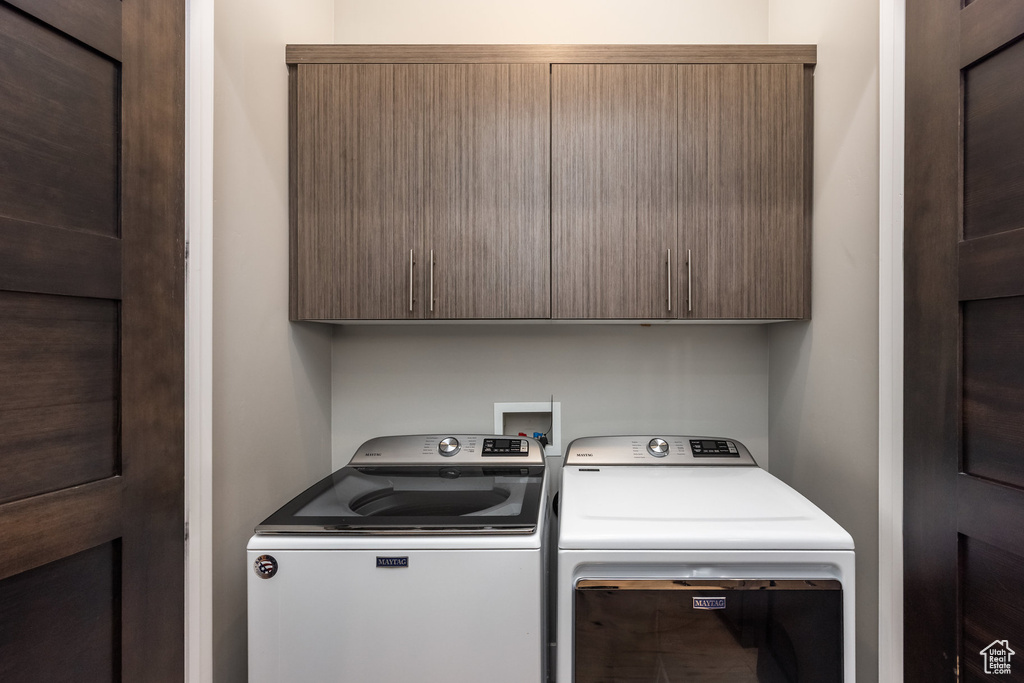 Laundry area featuring cabinet space and separate washer and dryer