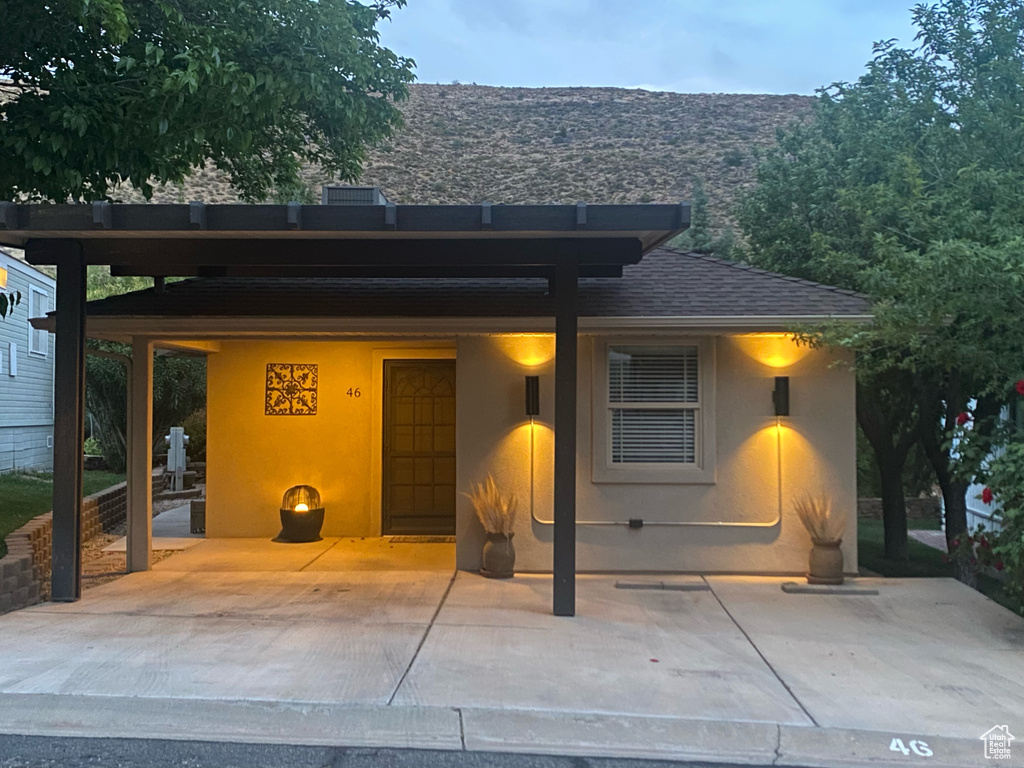 Exterior space featuring a shingled roof and stucco siding