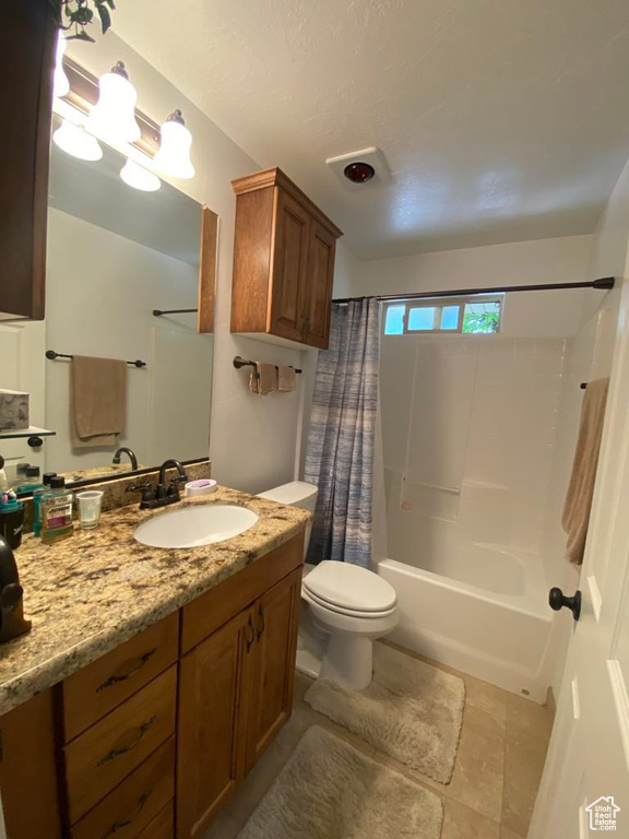 Bathroom with shower / bath combination with curtain, toilet, and vanity