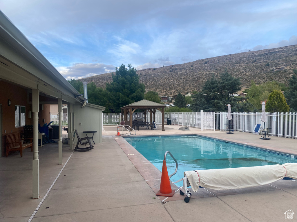 Community pool featuring fence, a gazebo, a patio, and a mountain view