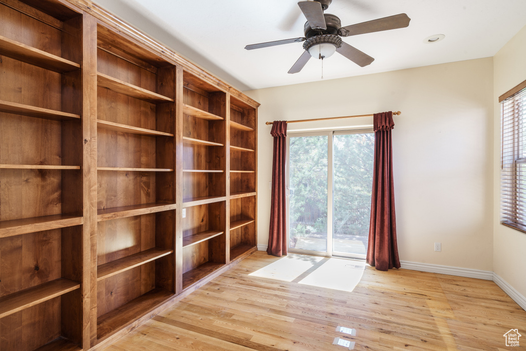 Unfurnished room with a ceiling fan, wood finished floors, and baseboards