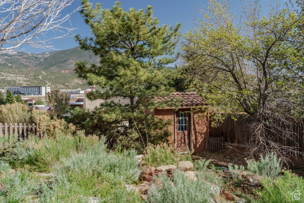 Exterior space with an outbuilding, a mountain view, and fence