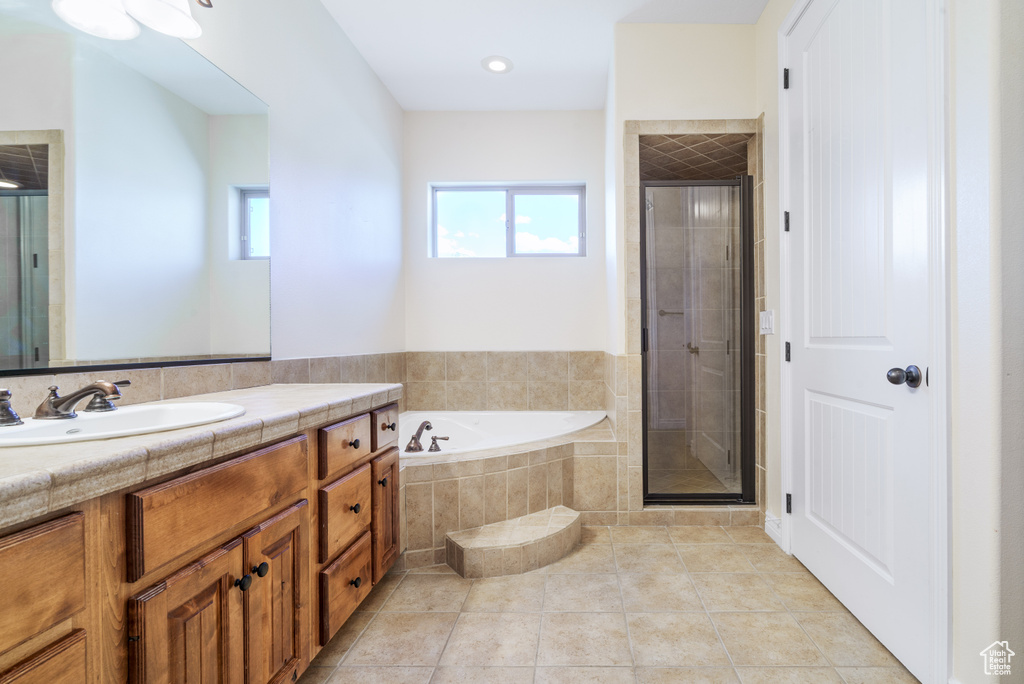 Bathroom featuring vanity, a garden tub, a shower stall, and tile patterned flooring