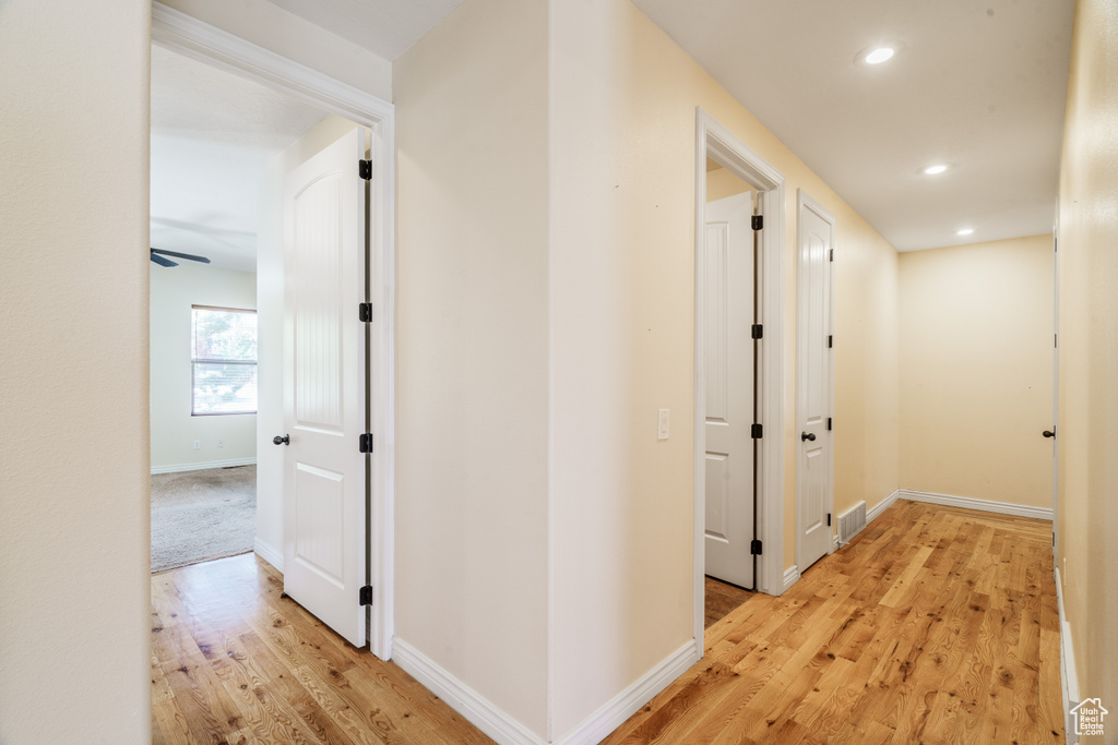 Hallway with visible vents, light wood-type flooring, recessed lighting, and baseboards