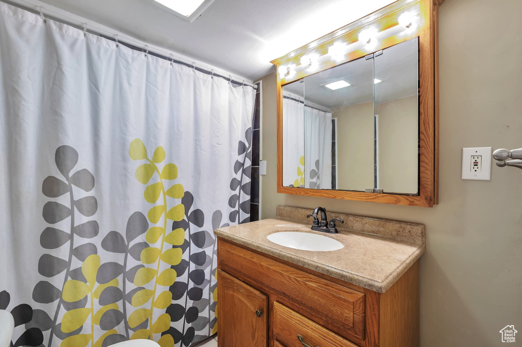 Bathroom with a shower with curtain and vanity